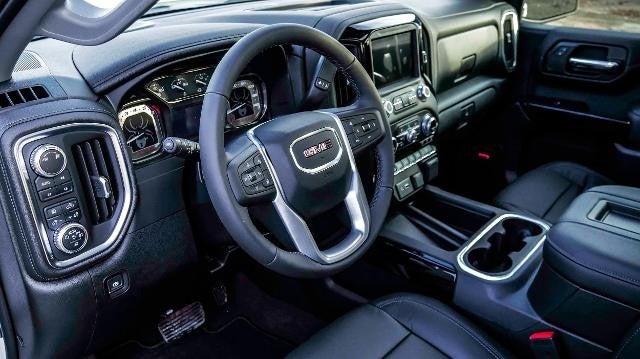 Interior view of the steering wheel and seats of a white GMC truck